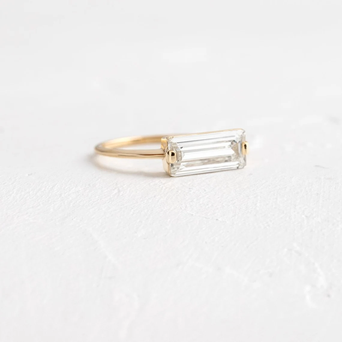 Streamlined silver setting holding a baguette moissanite with glassy clarity A piece that feels polished, structured, and effortlessly elevated Designed for contemporary elegance with a sharp edge - Image 3
