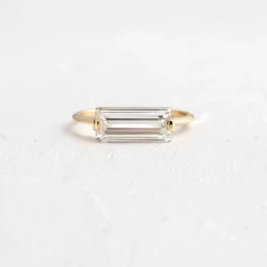 Streamlined silver setting holding a baguette moissanite with glassy clarity A piece that feels polished, structured, and effortlessly elevated Designed for contemporary elegance with a sharp edge