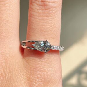 Fluid silver band holding a moissanite with asymmetrical micro accents A design that feels dynamic, artistic, and fashion-led Perfect for those who love subtle drama with elegance