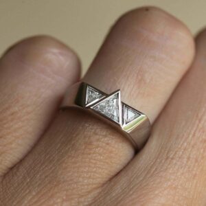 Geometric silver ring featuring precision-cut moissanite in a bold triangular layout A statement design that leans into edgy, architectural aesthetics Perfect for those who prefer modern jewelry with a strong attitude