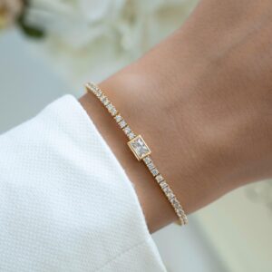 Elegant Emerald Cut Center Diamond Tennis Bracelet in 14K Yellow Gold with Bezel Set Round Accents Luxury Statement Bracelet Featuring Radiant-Cut Center Stone with Pavé Halo & Classic Minimal Link Design