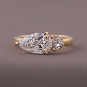 14K yellow gold pear cut diamond engagement ring with asymmetrical side stones, crafted in Modern unique design with a bold teardrop center, artistic balance, and refined luxurious sparkle