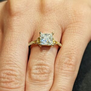 Boundless Radiance princess cut diamond engagement ring with delicate side accents, set in 14K yellow gold, minimalist vintage inspired design with refined sparkle