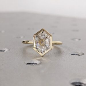 Modern hexagon-cut diamond engagement ring in a sleek bezel setting, crafted in 14K yellow gold, minimalist geometric design with clean lines and contemporary elegance
