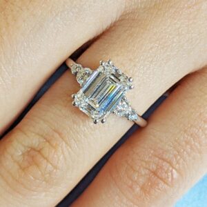Calm Radiance 14K White Gold Emerald Cut Diamond Engagement Ring with Trillion Side Stones Three Stone Diamond Ring Minimalist Luxury Bridal Ring Classic Step Cut Center Stone Fine Jewelry Gift for Women